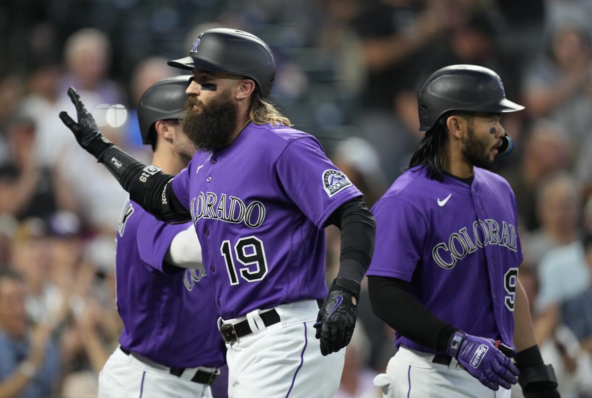 Colorado Rockies' Charlie Blackmon, front, is congratulated, after hitting a three-run home run, by Randal Grichuk, left, and Connor Joe during the sixth inning of the team's baseball game against the San Diego Padres on Tuesday, July 12, 2022, in Denver. (AP Photo/David Zalubowski)