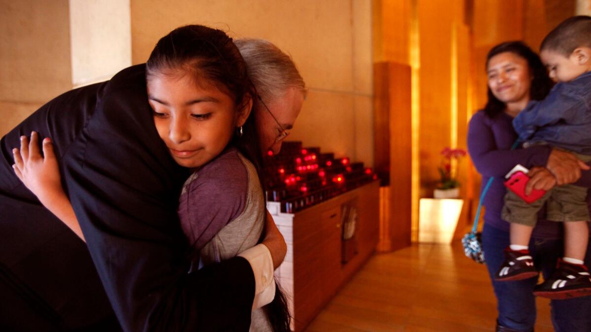 Los Angeles Archbishop Jose Gomez hugs Jersey Vargas, 10, inside the Cathedral of Our Lady of the Angels in Los Angeles in 2014.