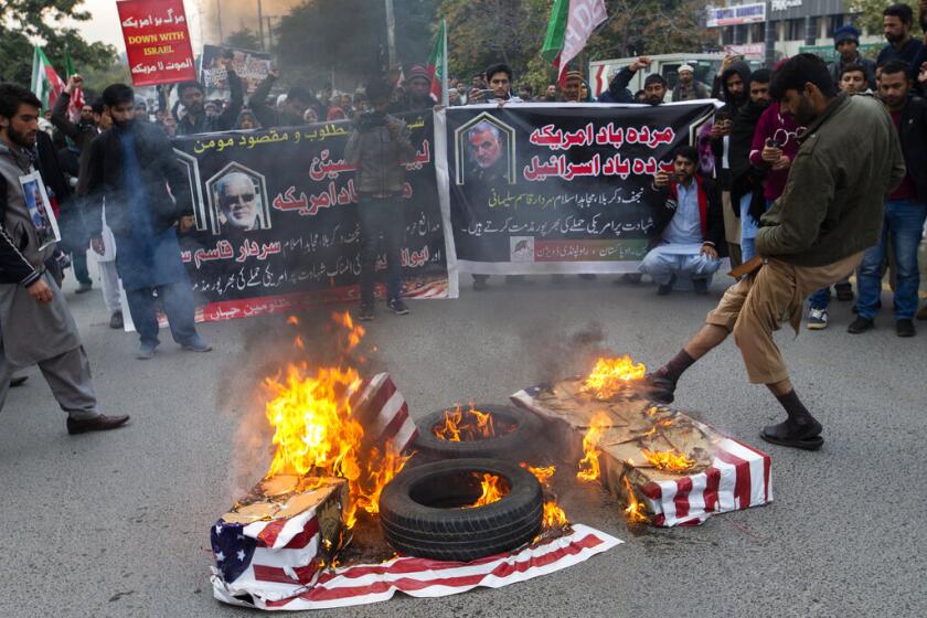 Unas personas queman banderas estadounidenses durante una protesta por el ataque de Estados Unidos que provocó la muerte del general iraní Qassem Soleimani, en Islamabad, Pakistán, el viernes 3 de enero de 2020. (AP Foto/B.K. Bangash)