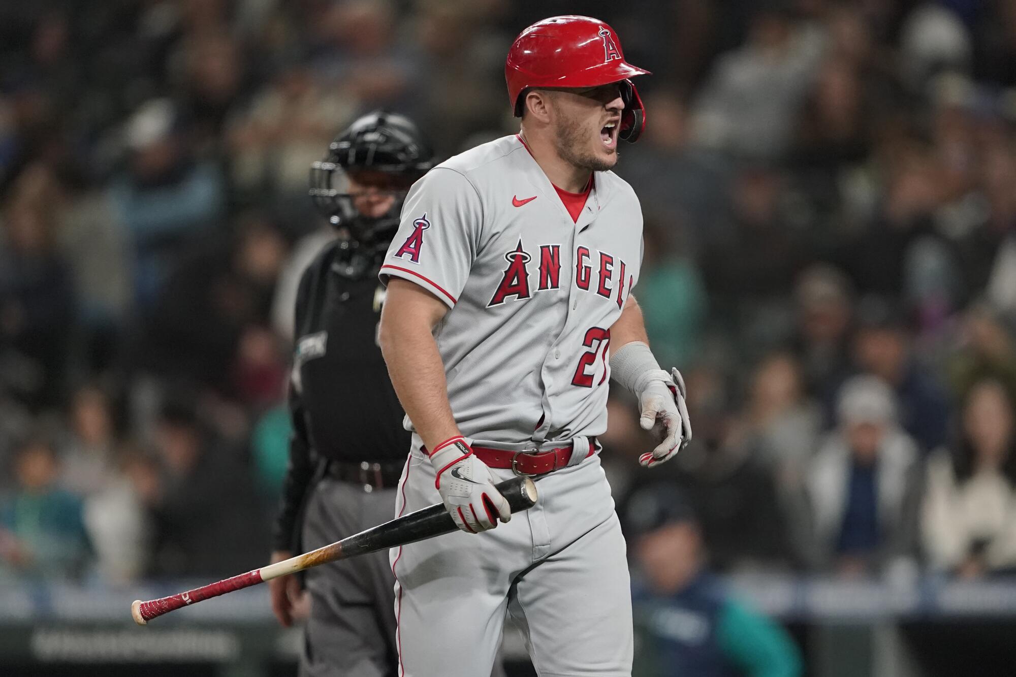 Angels star Mike Trout reacts after fouling a ball off his foot against the Seattle Mariners on June 18.
