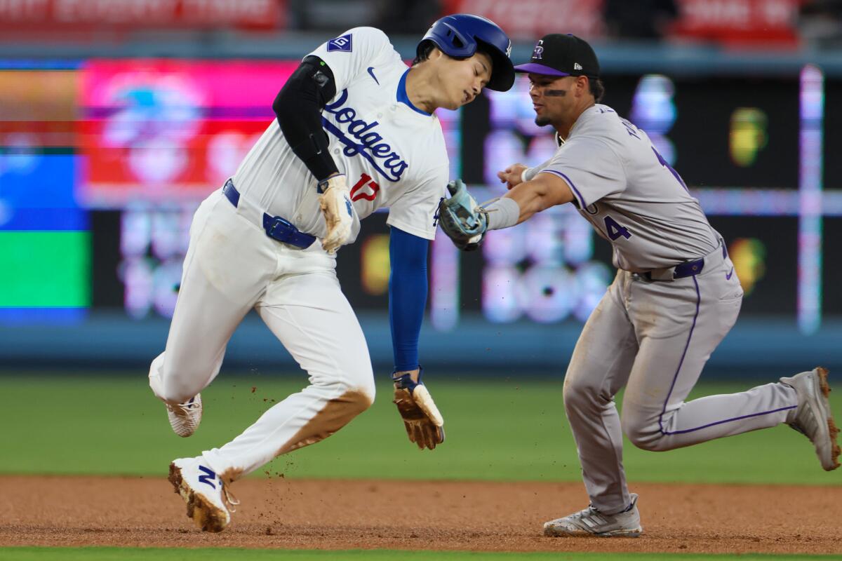 Colorado Rockies shortstop Ezequiel Tovar tags out Dodgers star Shohei Ohtani during the third inning Saturday.