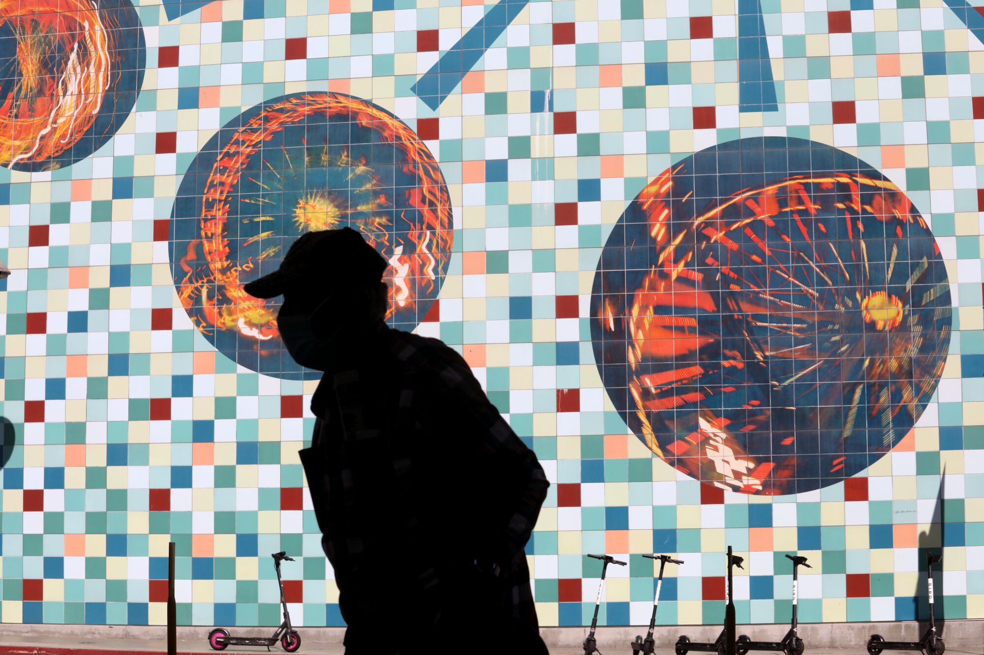 The silhouette of a person in front of a tile mosaic wall