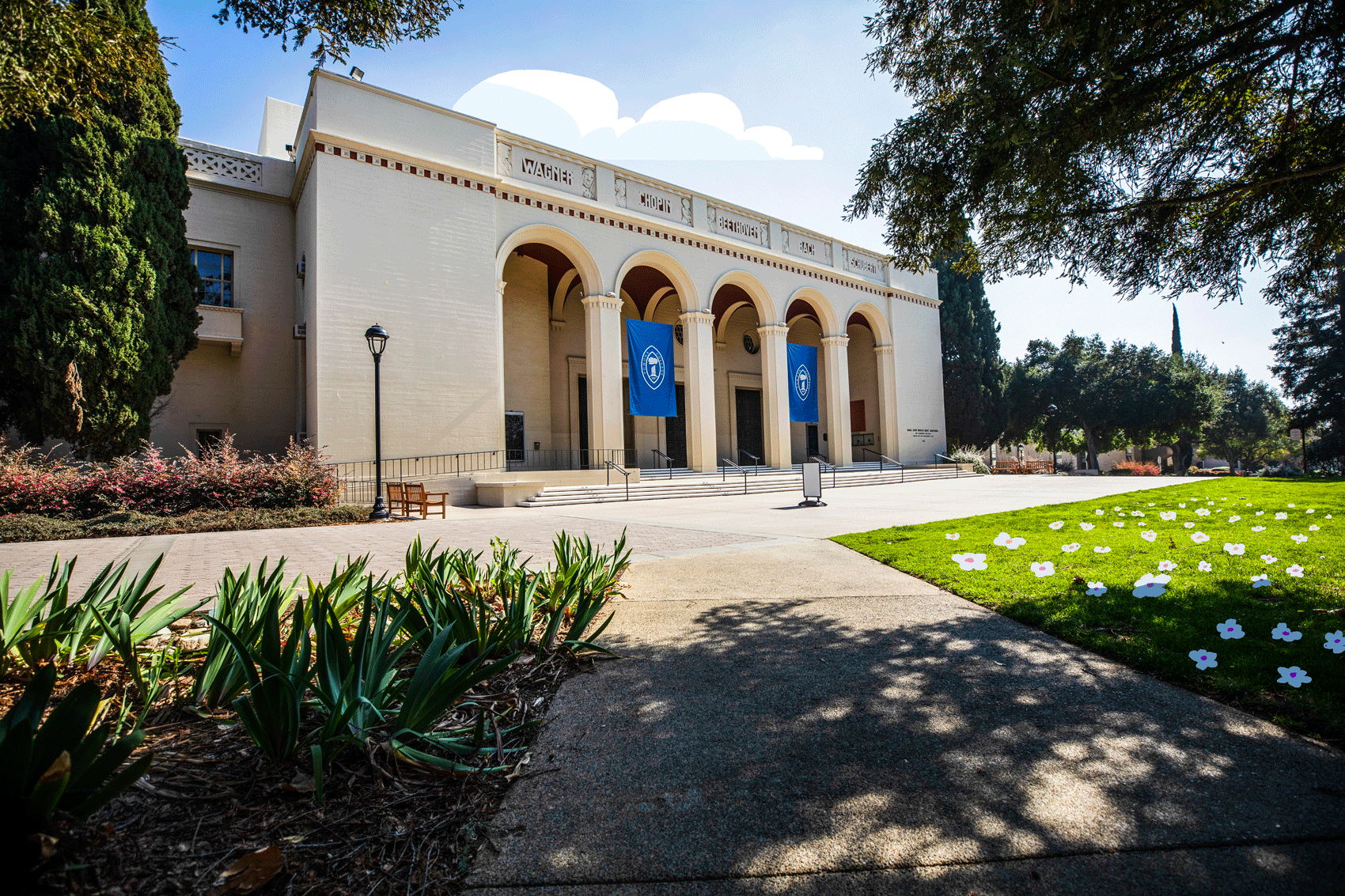A large building with arched entryways is seen with illustrated clouds and flowers.