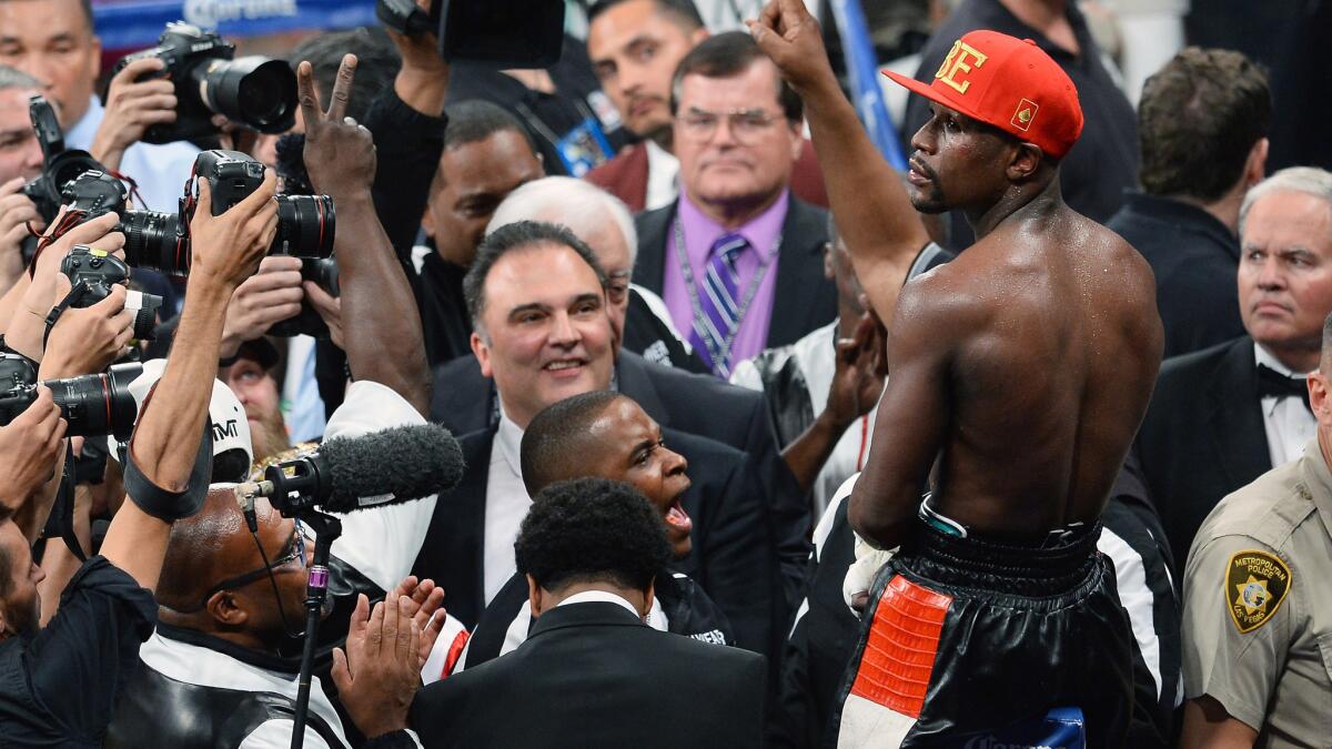 Floyd Mayweather Jr. celebrates in front of the cameras following his welterweight unification title victory over Marcos Maidana at the MGM Garden Arena in Las Vegas.
