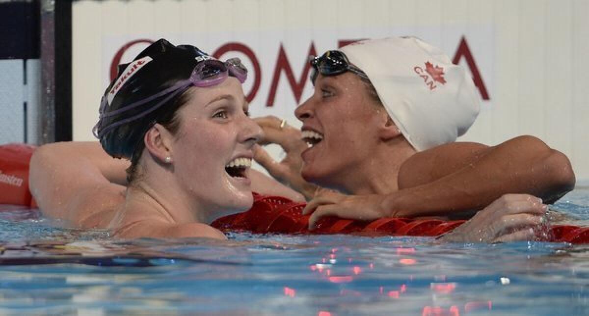 Missy Franklin, left, embraces bronze medalist Hilary Caldwell after winning the women's 200 meter backstroke at the world championships in Barcelona on Saturday.