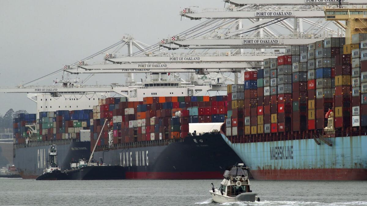 Container ships are unloaded at the Port of Oakland on July 2. The Commerce Department reported Wednesday that the U.S. trade deficit widened that month.
