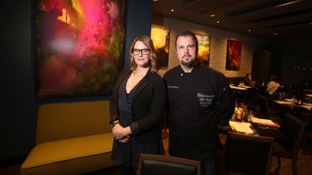 Co-owners Kate Perry and chef Mark McDonald stand in the dining room of Old Vine Kitchen & Bar at the Camp in Costa Mesa.
