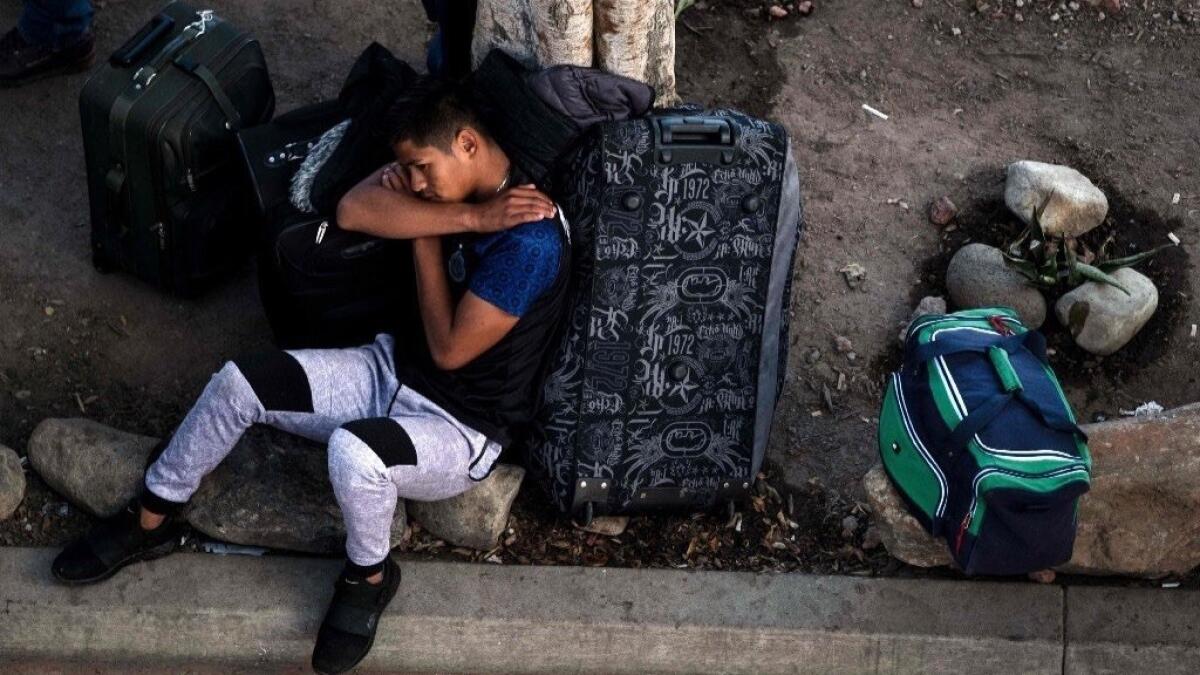A man rests outside El Chaparral port of entry in Tijuana last month while he waits for his turn to present himself to U.S. border authorities to request asylum.