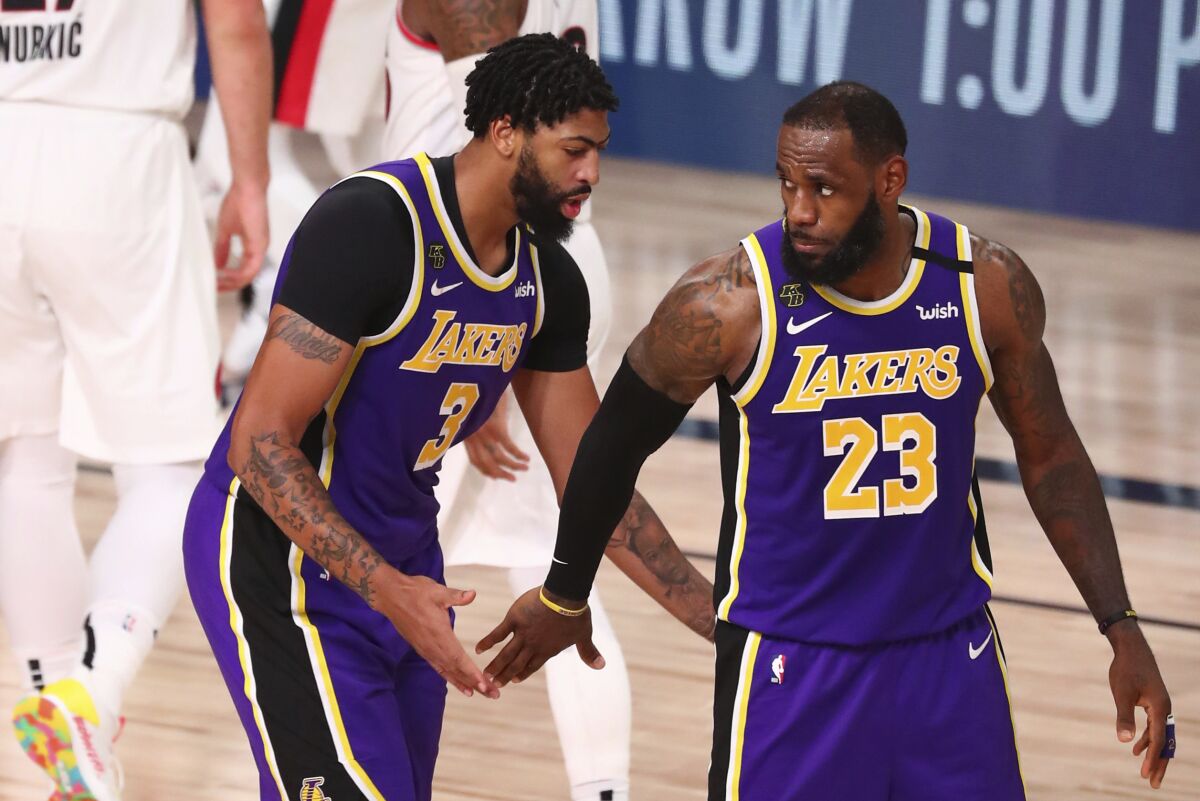 The Lakers' LeBron James, right, reacts after a dunk by teammate Anthony Davis, left, on Aug. 22, 2020.