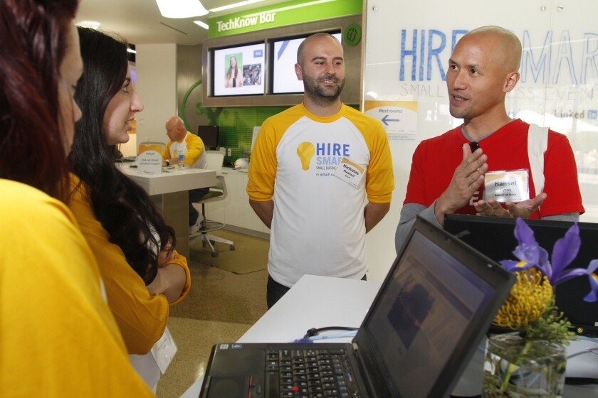 A small business owner, right, speaks with Intuit employees at an Intuit event in Mountain View, Calif. Intuit, which makes financial software, was offering advice on hiring new employees.
