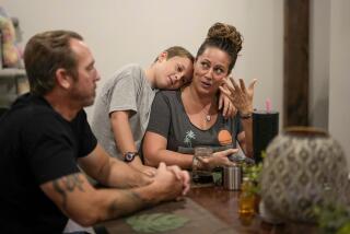 Christian O'Neil hugs his mother, Sara, during dinner at their home in Randall, Iowa, while she describes a scary incident she experienced while serving in the military.