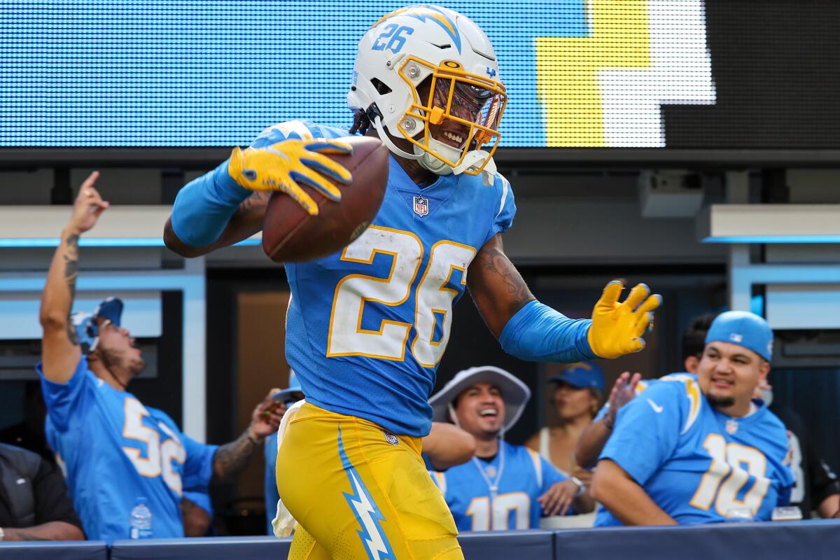 Chargers cornerback Asante Samuel Jr. celebrates after intercepting a pass as fans in Chargers jerseys cheer.