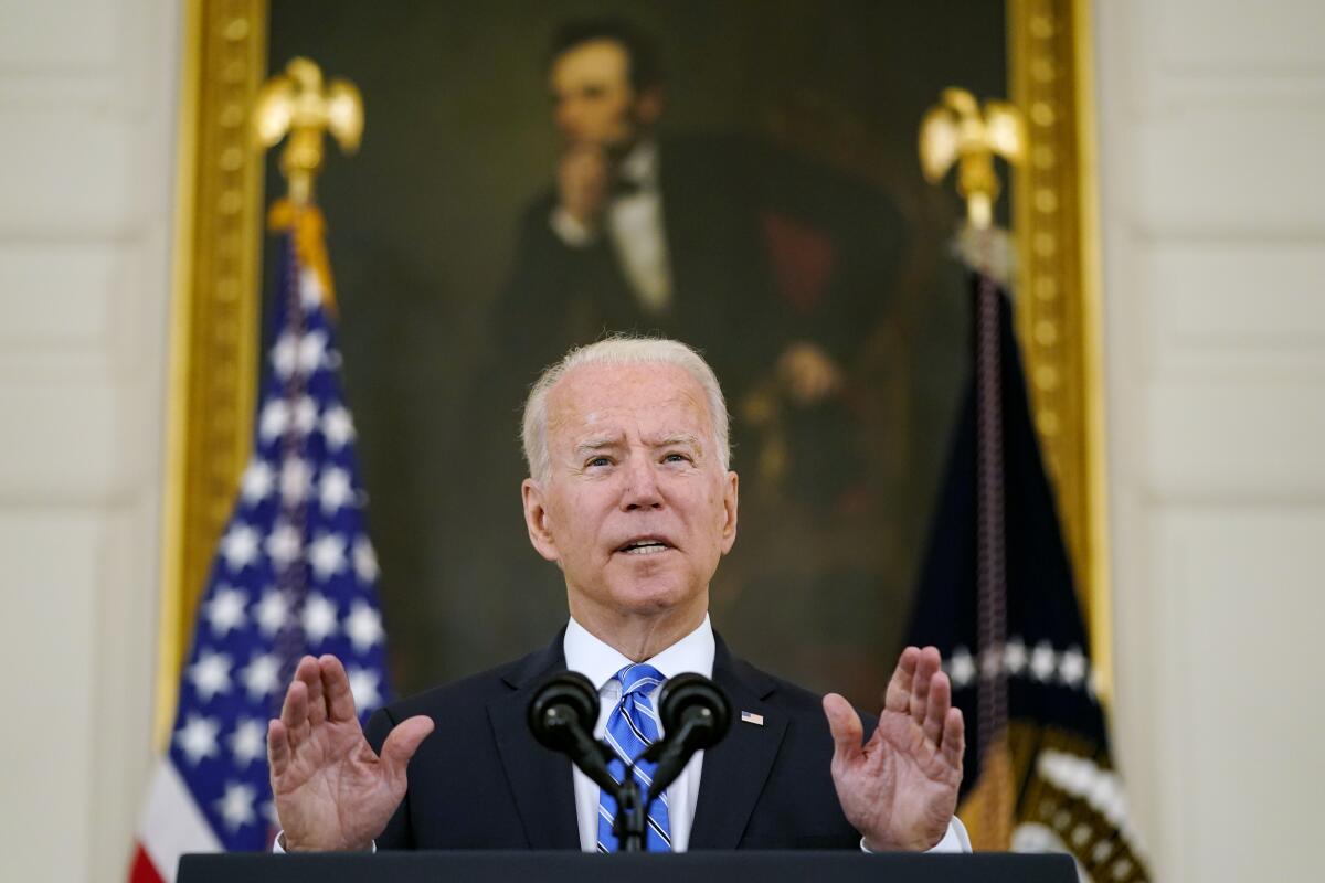 President Biden speaking below Lincoln's portrait in the White House.