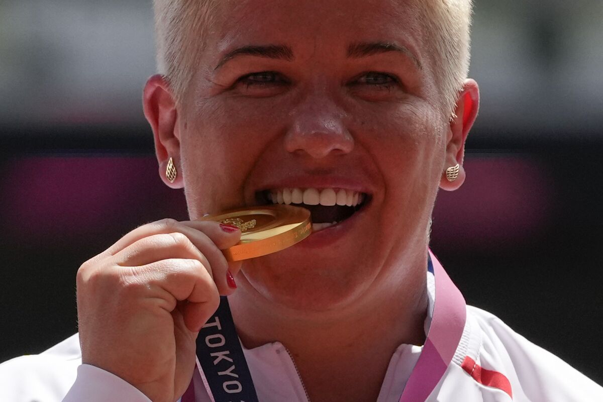 FILE - Gold medalist Anita Wlodarczyk, of Poland, poses during the medal ceremony for the women's hammer throw at the 2020 Summer Olympics, Aug. 4, 2021, in Tokyo, Japan. Wlodarczyk will miss the rest of the season after undergoing surgery for a thigh injury she sustained while chasing a thief trying to break into her car, it was announced Wednesday, June 15, 2022. The three-time Olympic gold medalist from Poland wrote on Instagram that she “totally severed” a thigh muscle during the incident last week, but remains intent on competing at the 2024 Paris Games. (AP Photo/Francisco Seco, file)