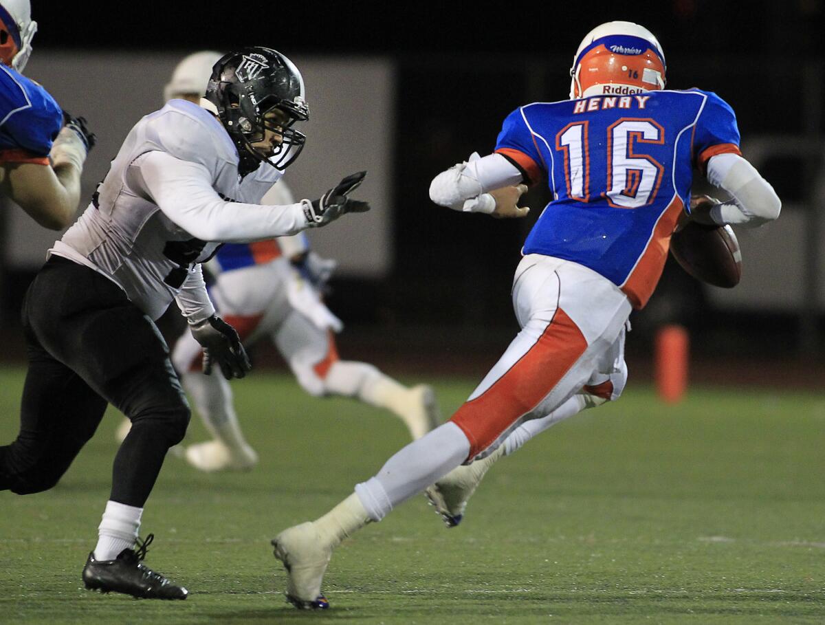 Westlake quarterback Malik Henry is forced out of the pocked by Servite's Andrew Carillo IV during a Pac-5 Division playoff game on November 15, 2013.