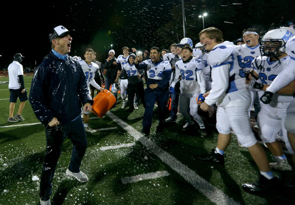 Crescenta Valley High first-year football coach Hudson Gossard gets soaked by his players after Crescenta Valley posted a 19-16 win against Simi Valley to capture the CIF Southern Section Division X championship.
