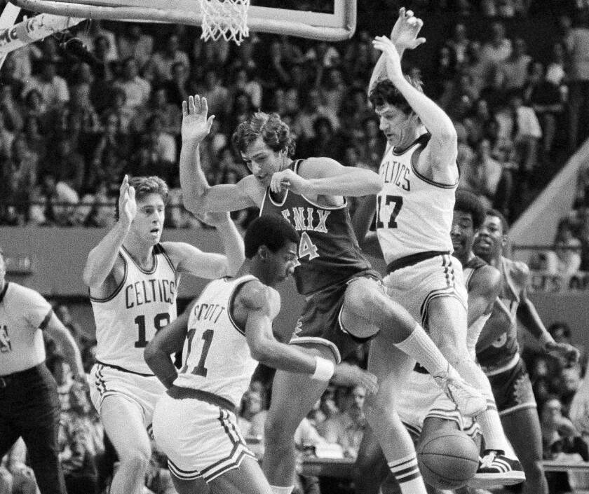 FILE - Boston's Dave Cowens, left, Charlie Scott (11) and John Havlicek team up on Paul Westphal, of the Phoenix Suns, as they try to go for a rebound during the first period of an NBA championship game at the Boston Garden, June 4, 1976. The longest game yet at the NBA Finals happened between the Boston Celtics and Phoenix Suns with the series tied at 2 apiece. (AP Photo/Peter Southwick, File)