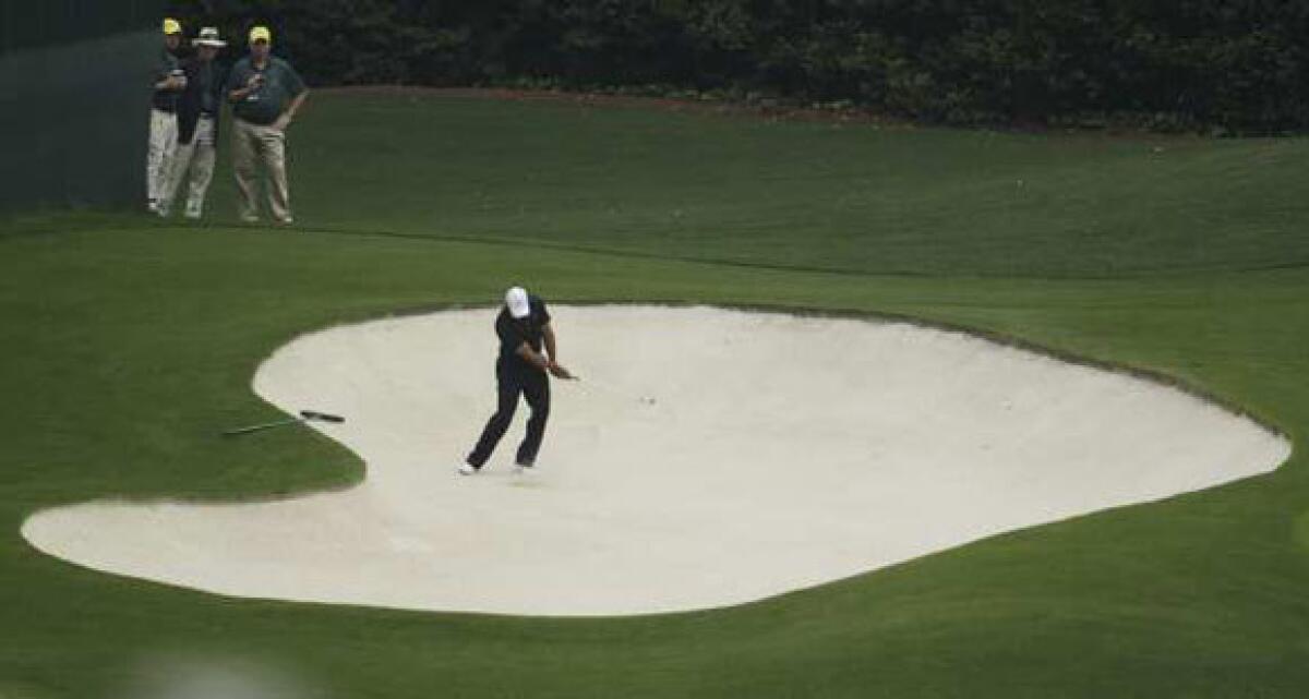Tiger Woods hits out of a sand trap during a practice round at the Masters.