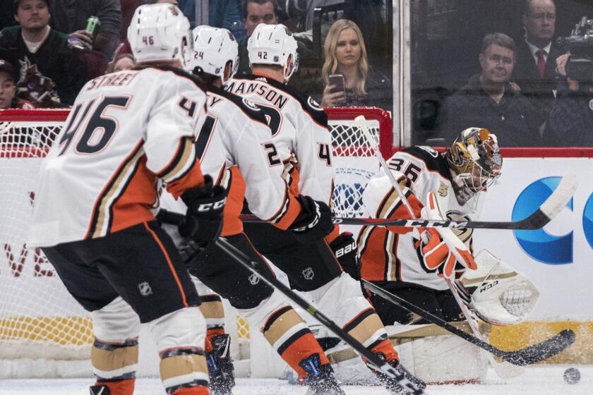 Anaheim Ducks goalie John Gibson (36) blocks a shot bu the Arizona Coyotes as teammates Ben Street (46), Carter Rowney (24) and Josh Manson (42) watch during the first period of an NHL hockey game Saturday, Oct. 6, 2018, in Glendale, Ariz. (AP Photo/Darryl Webb)