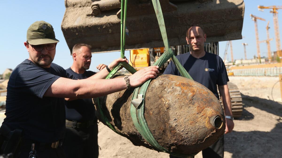 Bomb disposal technicians steady an unexploded bomb from World War II after its deactivation April 20 in Berlin.