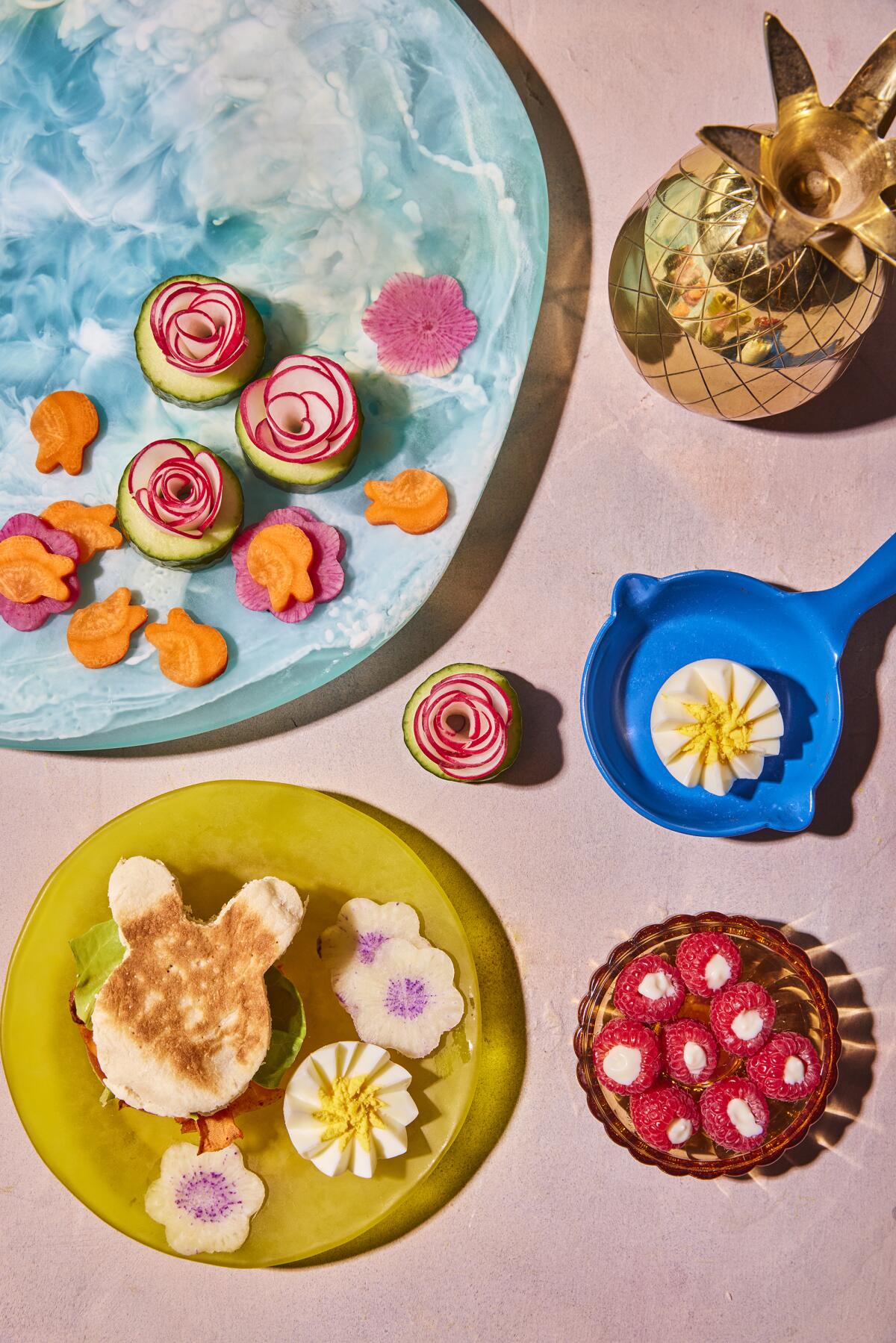 This image released by Harvest shows a breakfast recipe for carrot bacon along with watermelon radish and eggs in the shape of flowers and raspberry parfait bites from the book "Dictator Lunches: Inspired Meals That Will Compel Even the Toughest of Children" by Jenny Mollen. (Lauren Volo/Harvest via AP)