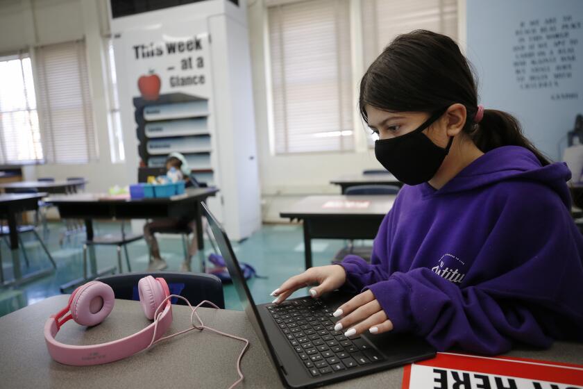 WEST HOLLYWOOD, CA - MARCH 18: Sixth grade student Mia Rivera, 12, right, with sister second grade student Sophia Rivera, 8, completing online study while sitting in front of the BARD HVAC unit with latest in HVAC technology in the "Beyond The Bell" classroom for students of employees on campus at West Hollywood Elementary School as Los Angeles Unified School District (LAUSD) Board Member Nick Melvoin, representing District 4 visits West Hollywood Elementary School and various other schools in his district to do an official check on preparations for reopening. The walking tour included the principal, Dr. Elizabeth Lehmann, LAUSD officials, a parent, West Hollywood Mayor Lindsay Horvath and Franny Parrish, with (CSEA), which represents school clerical workers and library aides, as they viewed modifications made to the school with COVID-19 considerations. West Hollywood Elementary School on Thursday, March 18, 2021 in West Hollywood, CA. (Al Seib / Los Angeles Times).