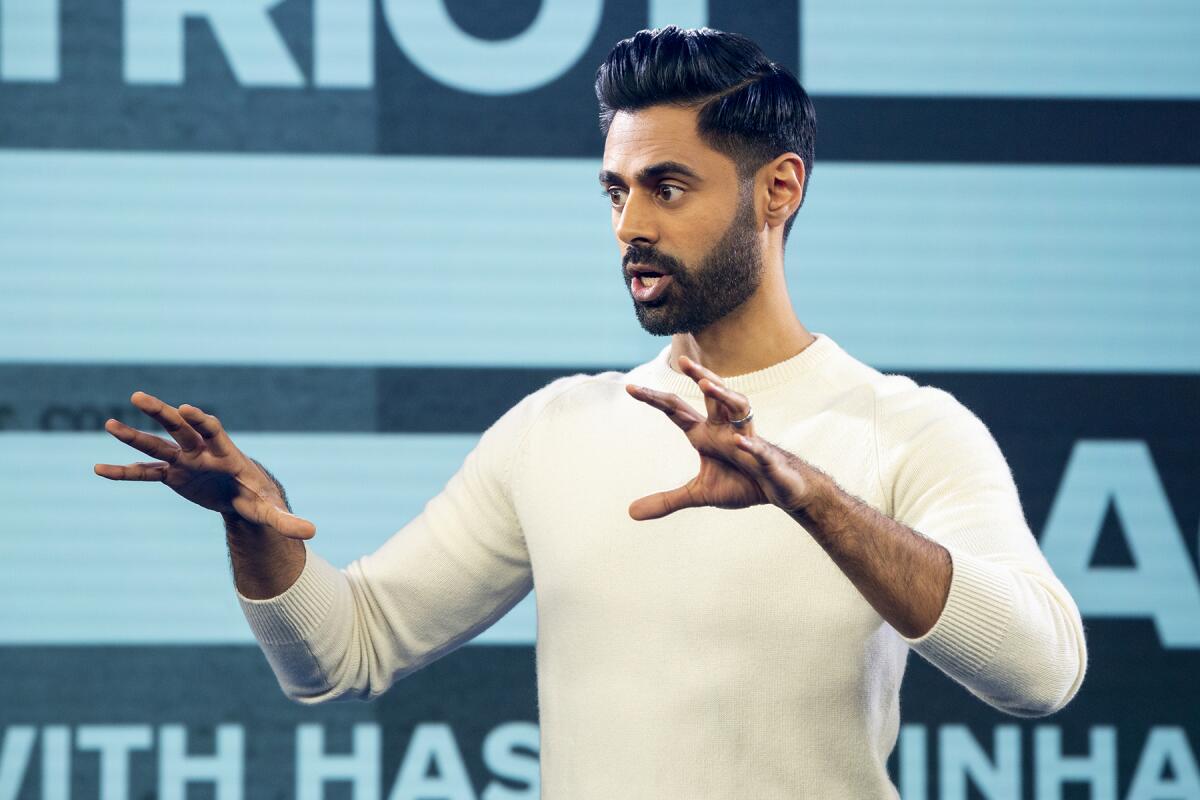 A man with a beard gestures with both hands while talking