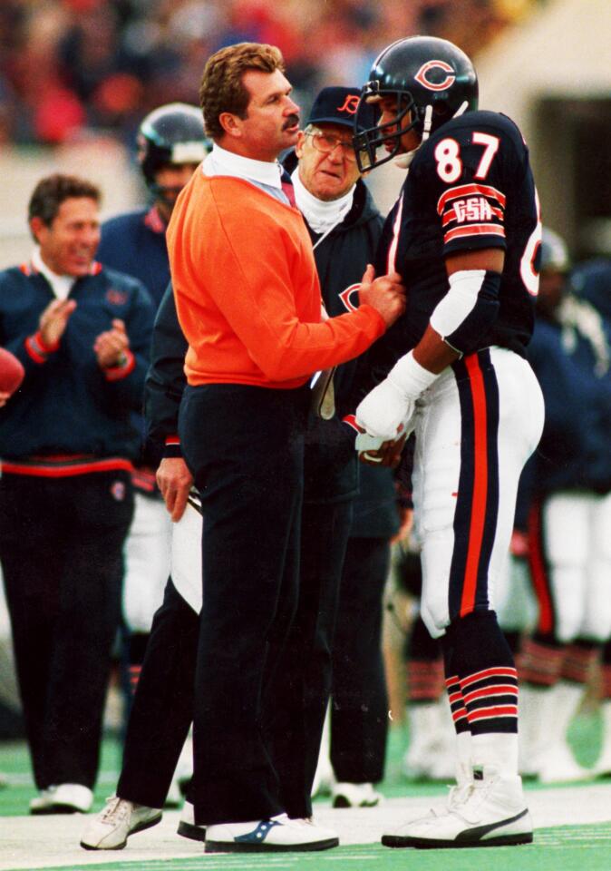 Bears coach Mike Ditka huddling with tight and Emery Moorehead.