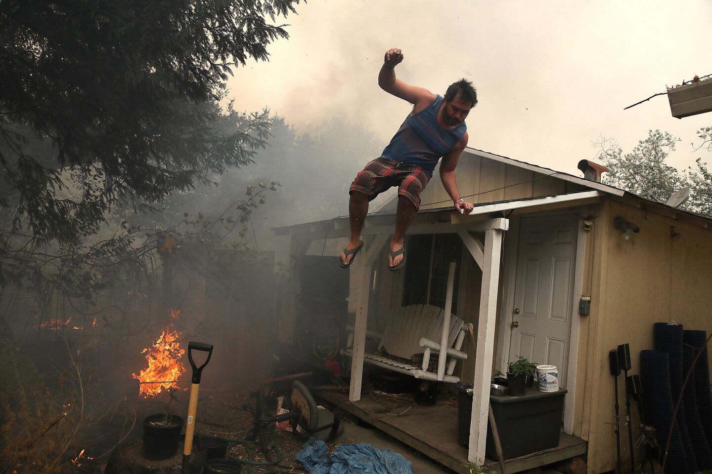A resident rushes to save his home as fire moves through the area in Glen Ellen, California.