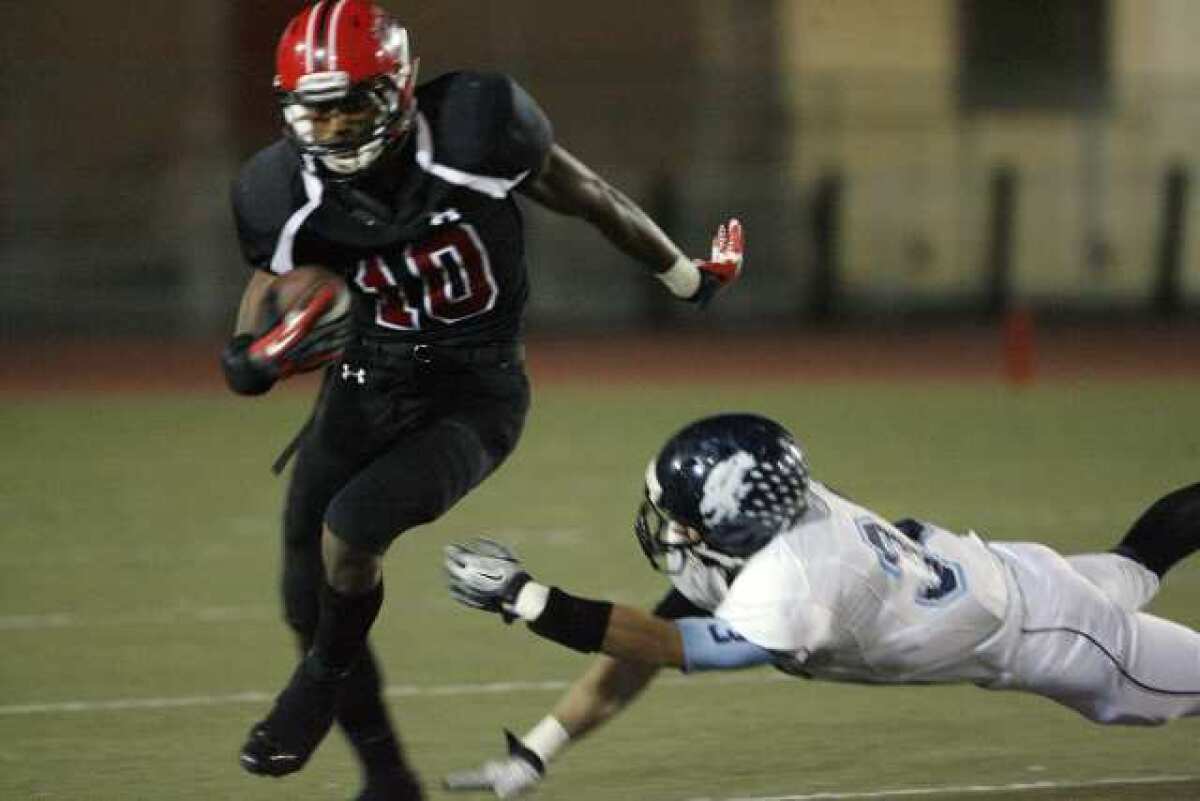 Glendale receiver Michael Davis avoids a Crescenta Valley tackler and heads downfield.