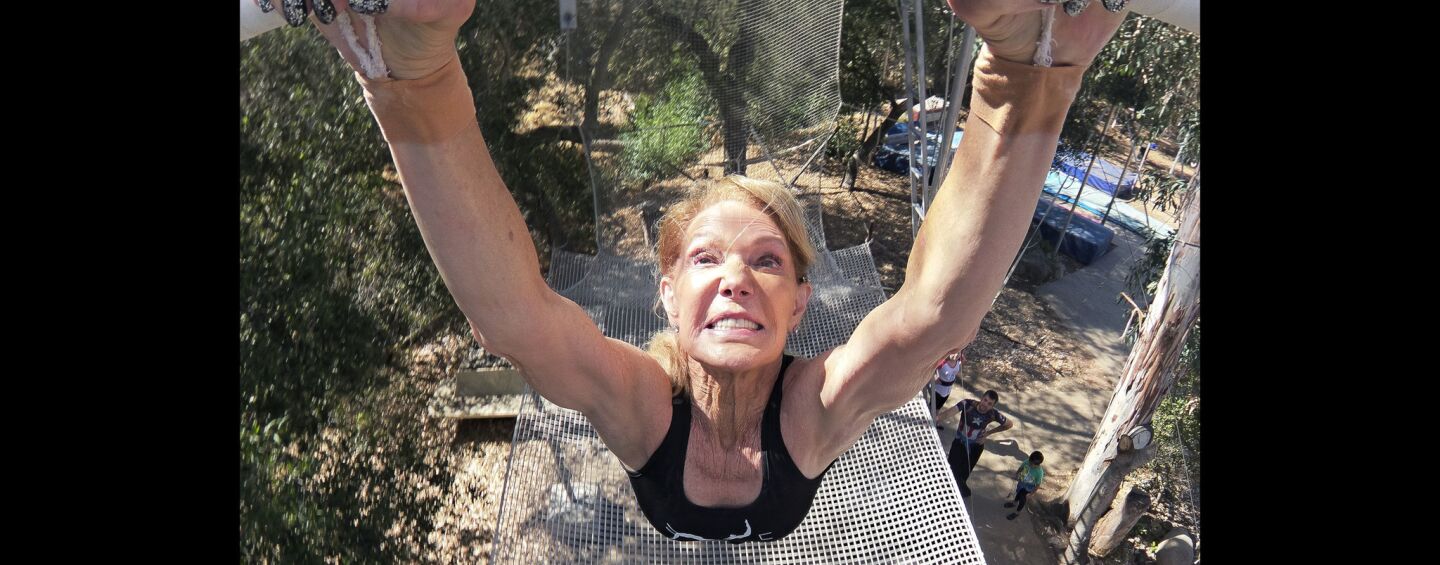 Betty Goedhart, 85, grips the trapeze as she swings out over the net.
