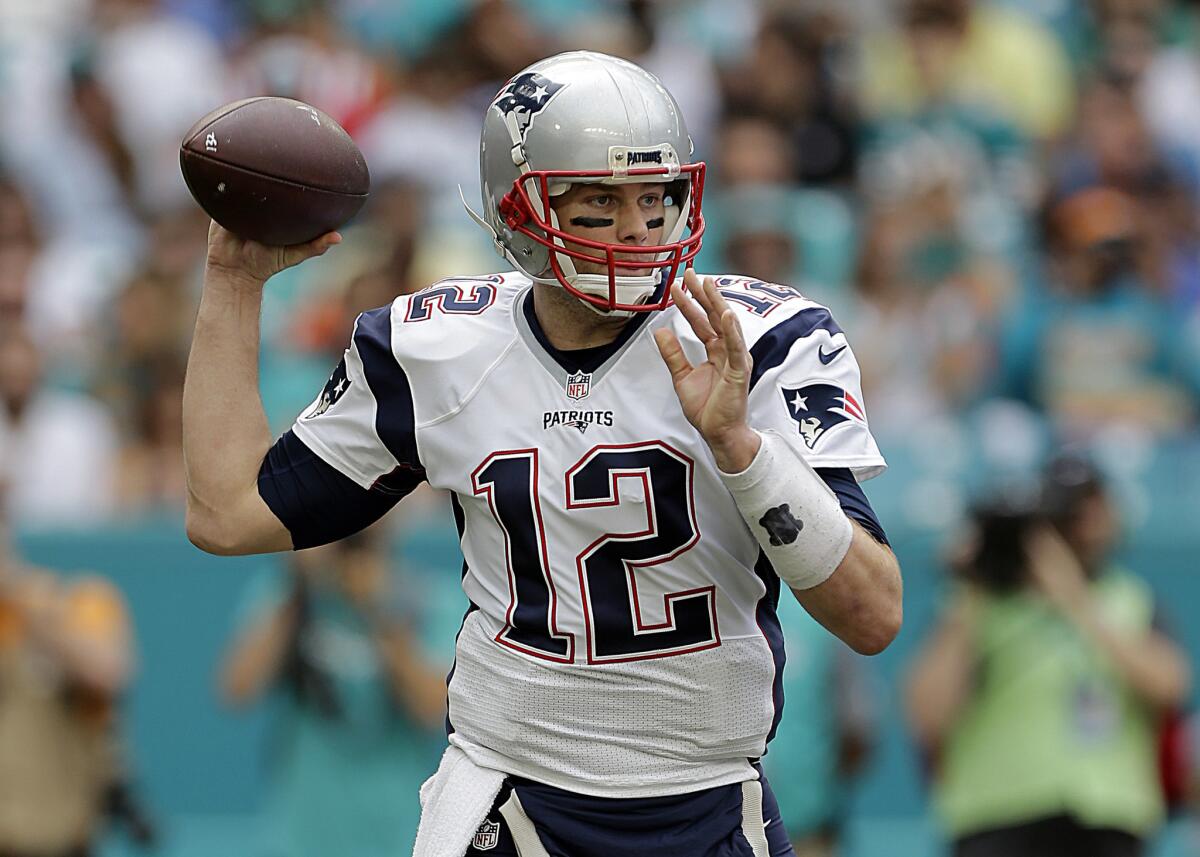 New England quarterback Tom Brady looks to pass against the Dolphins in Miami on Jan. 1.