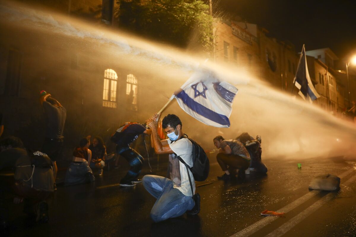 Protesters in Jerusalem are targeted with a police water cannon earlier this month.