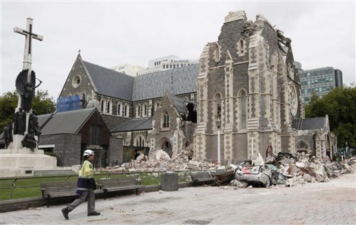FILE - In this Feb. 26, 2011 file photo, a relief worker walks past the earthquake-damaged Christchurch Cathedral in Christchurch, New Zealand. The iconic downtown cathedral in central Christchurch will be deconsecrated and partially demolished due to earthquake damage earlier this year. The safety measure will allow authorities to decide whether to retain any portion of the city's most well-known building. (AP Photo/Mark Baker, File)