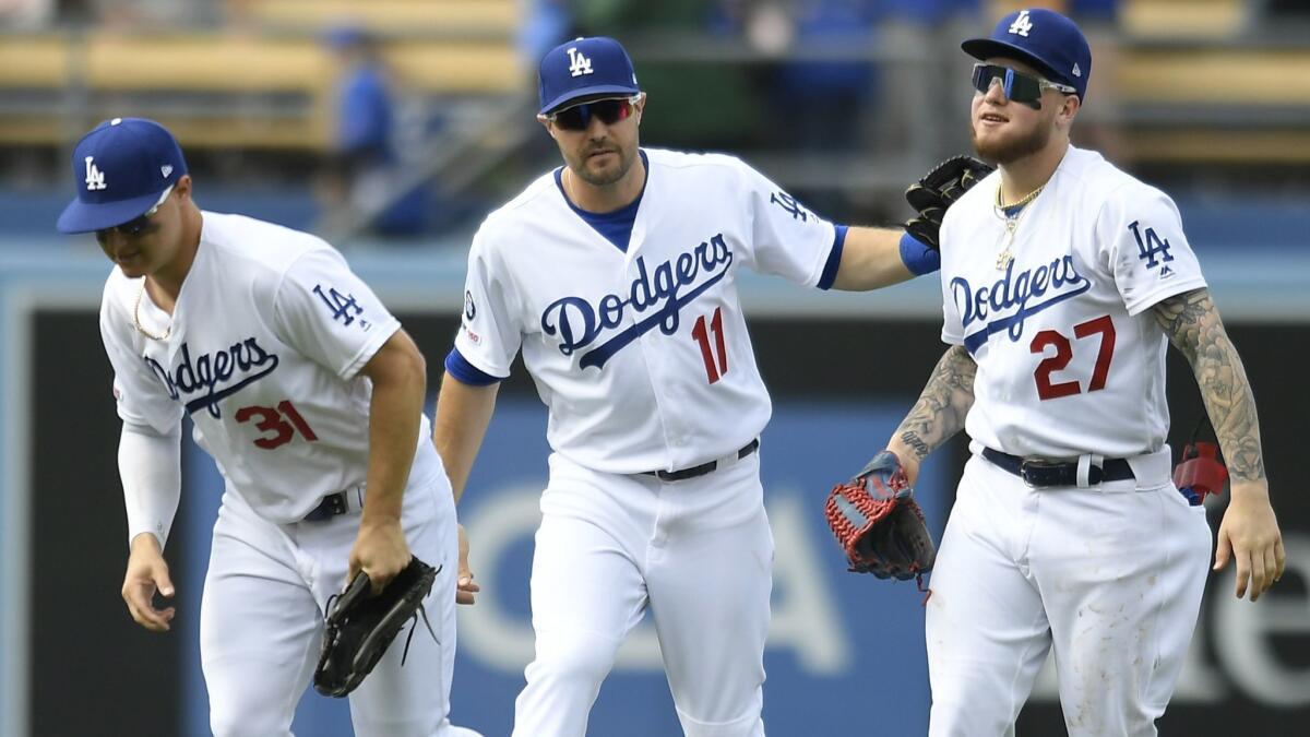 Dodgers outfielders Joc Pederson (3), A.J. Pollock (11) and Alex Verdugo (27) celebrate at the end of the game against the Pittsburgh Pirates at Dodger Stadium on April 28. Dodgers won 7-6.