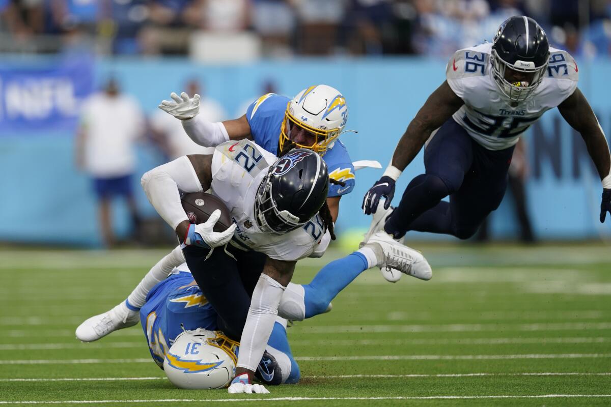 Chargers Nick Niemann (31) and Alohi Gilman tackle Titans running back Derrick Henry.
