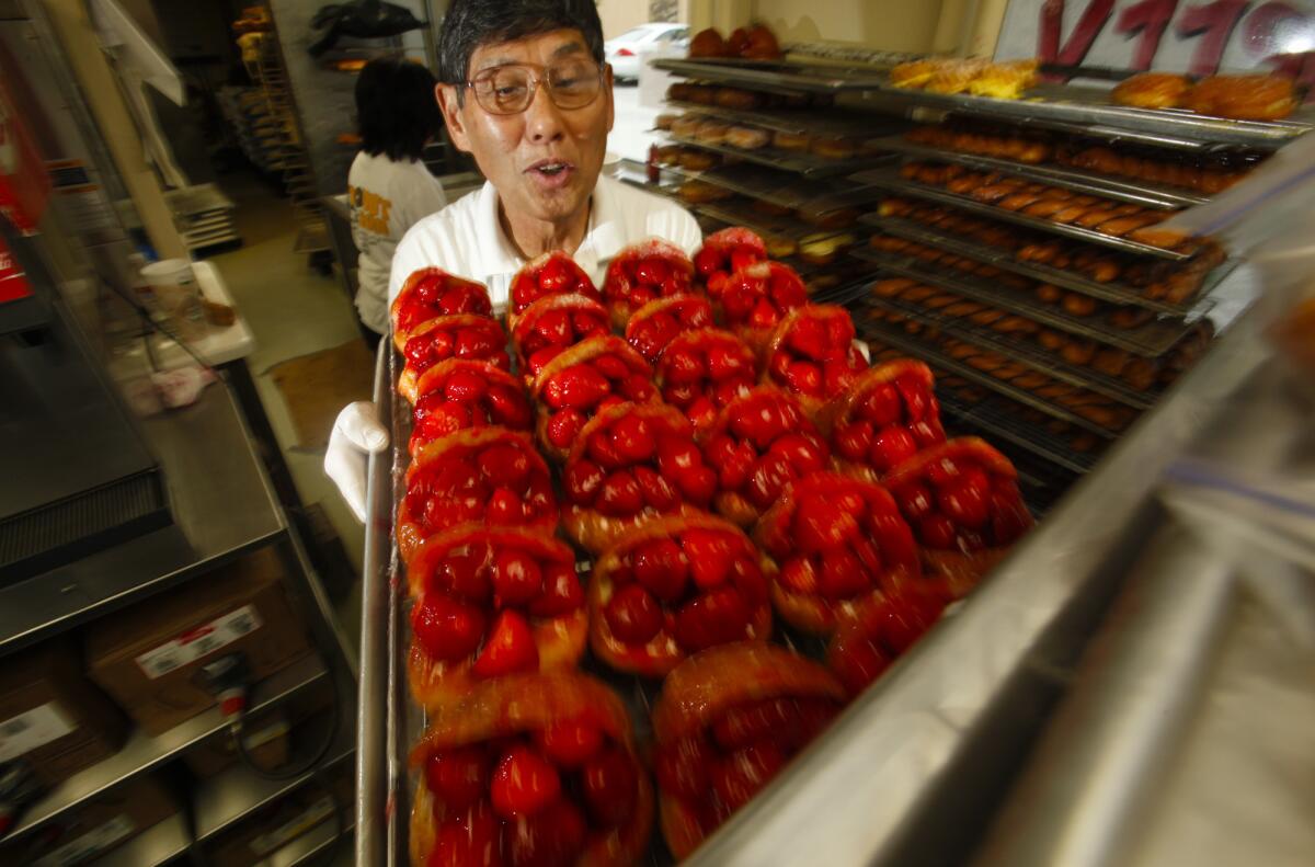 The Donut Man founder Jim Nakano with a tray of his strawberry donuts in 2011. The shop will expand to downtown L.A.'s Grand Central Market next year.
