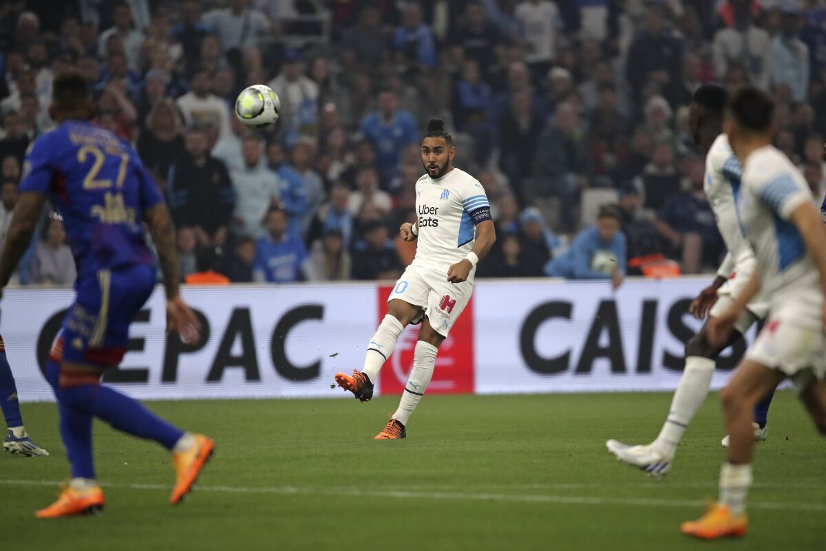 Marseille's Dimitri Payet, center, passes the ball during the French League One soccer match between Marseille and Lyon in Marseille, France, Sunday, May 1, 2022. (AP Photo/Daniel Cole)