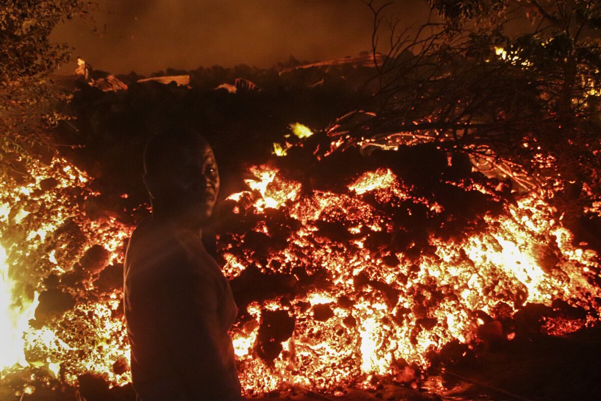 Una persona permanece de pie frente a la lava de la erupción del Monte Nyiragongo, en Buhene,