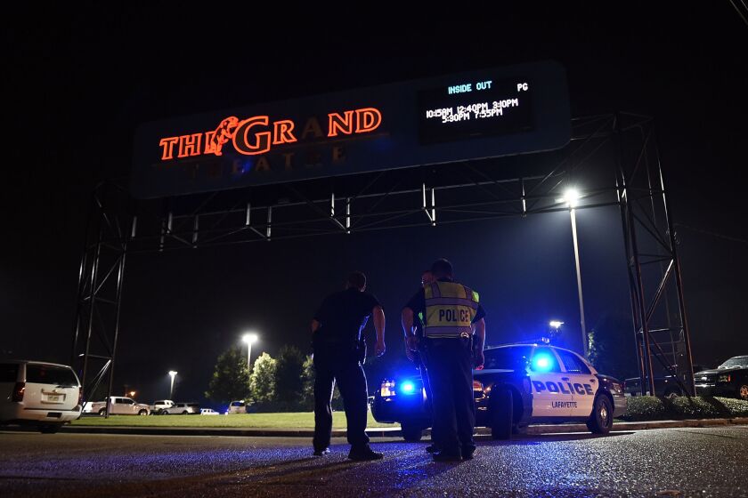 Police stand outside the Grand Theatre after a shooting Thursday night in Lafayette, La.