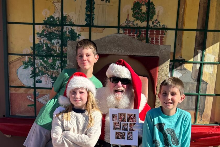Christine Kratt and her kids, Travis, 13, Charlotte, 9 and Brandon, 10, visited Santa Sunday by the park's Gingerbread House.