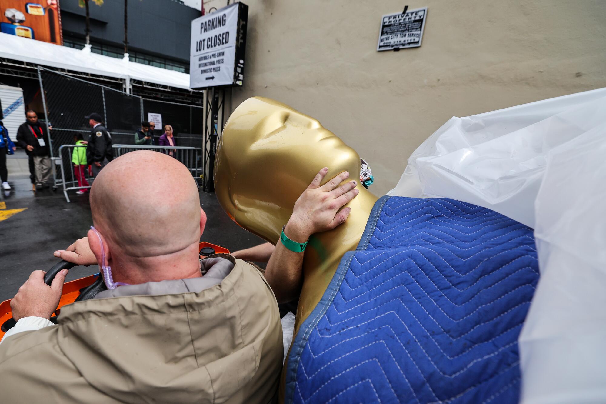 Crews deliver an outsized Oscar statue as preparations for the 95th Academy Awards on Hollywood Blvd. continue. 