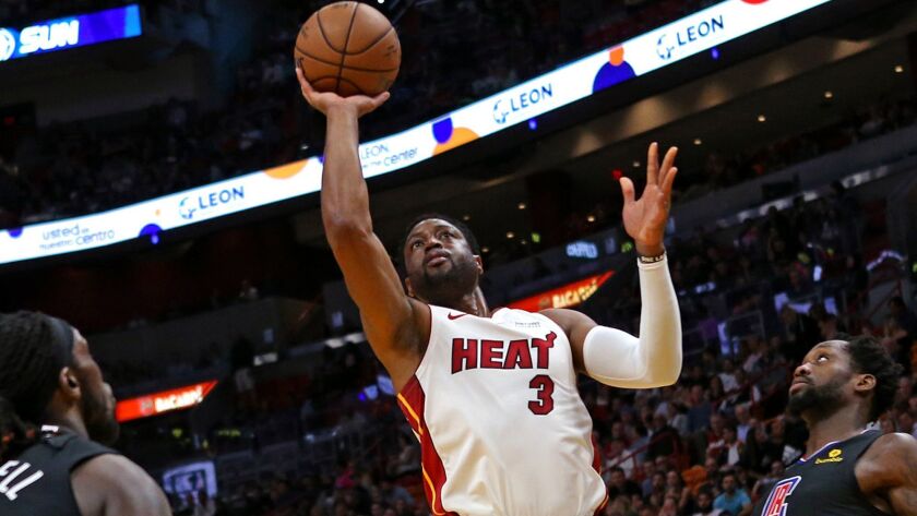 Miami Heat guard Dwyane Wade drives for a layup between Clippers forward Montrezl Harrell, left, and guard Patrick Beverley during the first half Wednesday.