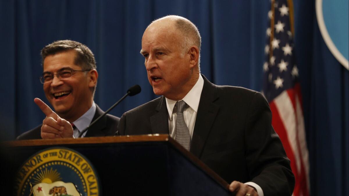 California Governor Jerry Brown gestures as Attorney General Xavier Becerra laughs during a press conference at the California State Capitol on March 7.