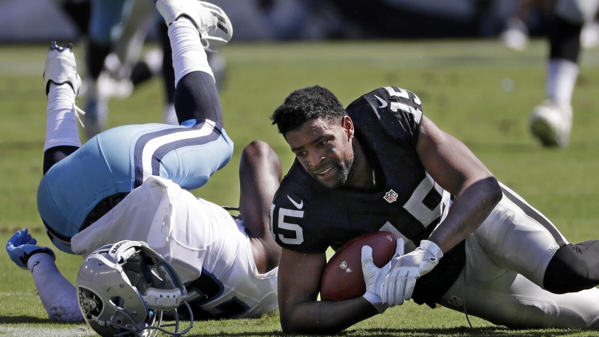 Raiders receiver Michael Crabtree loses his helmet after making a leaping catch against the Titan on Sunday.