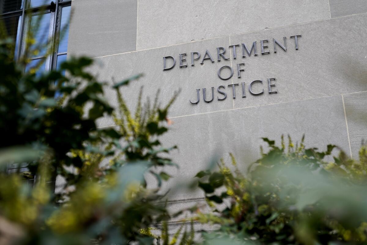 A sign marks an entrance to the Robert F. Kennedy Department of Justice Building in Washington.