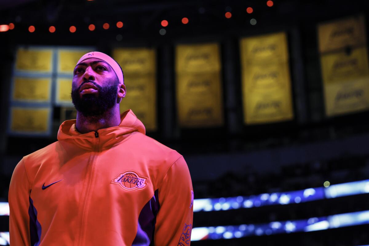 Lakers star Anthony Davis listens to the national anthem before a 133-112 win over the Charlotte Hornets.