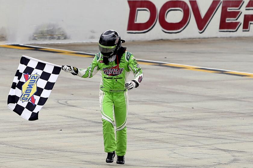 NASCAR driver Daniel Suarez takes a victory lap with the checkered flag Sunday after winning the Xfinity Series race at Dover.