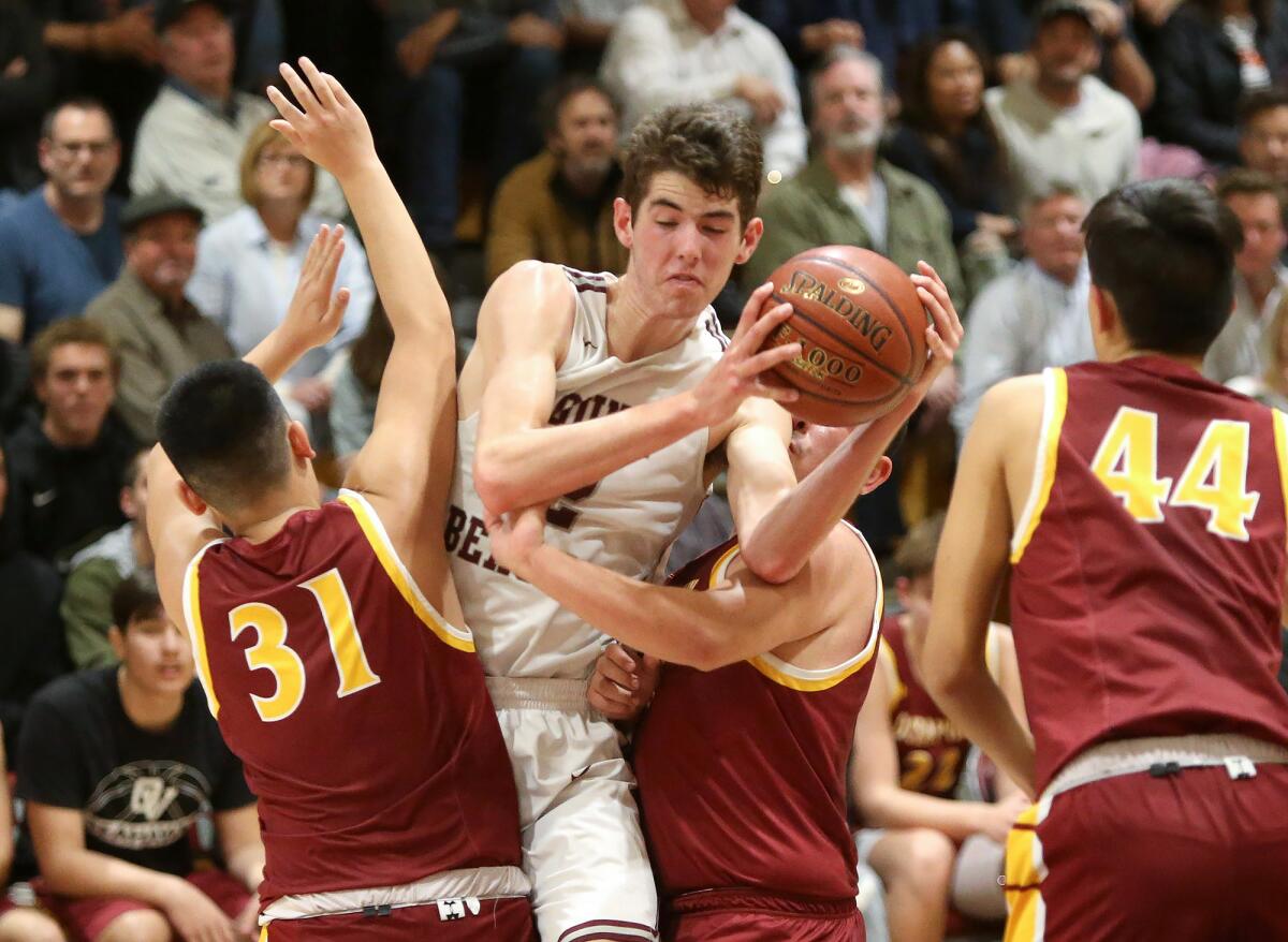 Laguna Beach's Nolan Naess, center, is fouled as he drives between Ocean View’s Ryan Vu, left, and Emilio Martinez, second to right, in the first round of the CIF Southern Section Division 3AA playoffs on Wednesday.