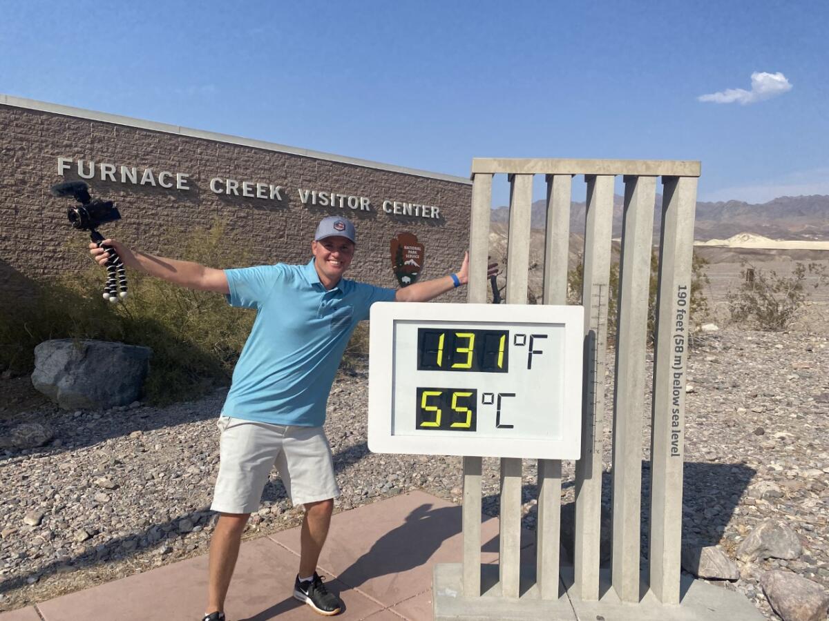Dan Markham poses in front of a thermometer that reads 131 degrees.